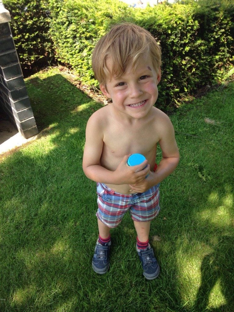 Child using Solar Buddies to apply sunscreen independently