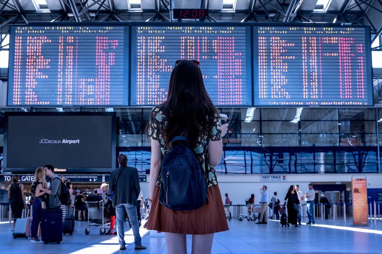 Cancun International Airport: How To Stay Safe & Navigate It, girl reading an airport board